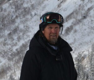 Skier wearing helmet and goggles on snowy slope