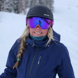 Smiling skier wearing helmet and mirrored goggles
