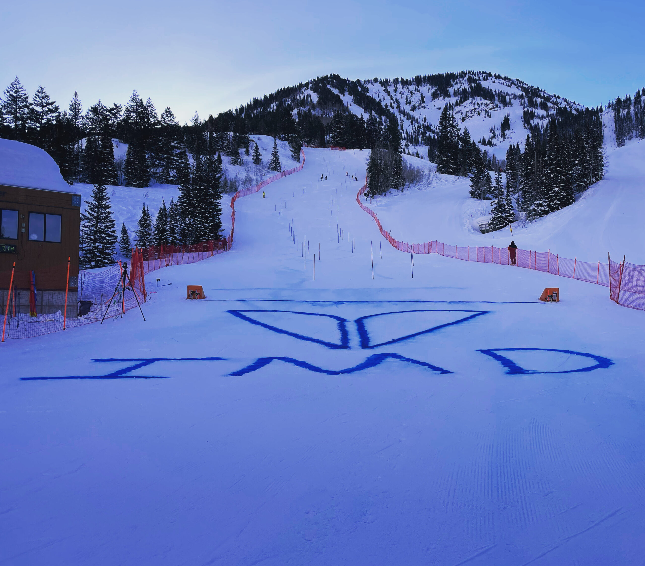 Snowy ski slope with mountain and blue lettering