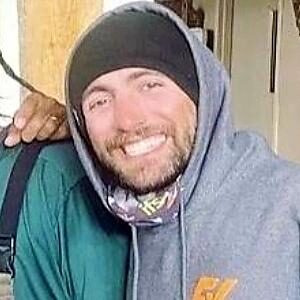 Smiling man wearing gray hoodie and beanie