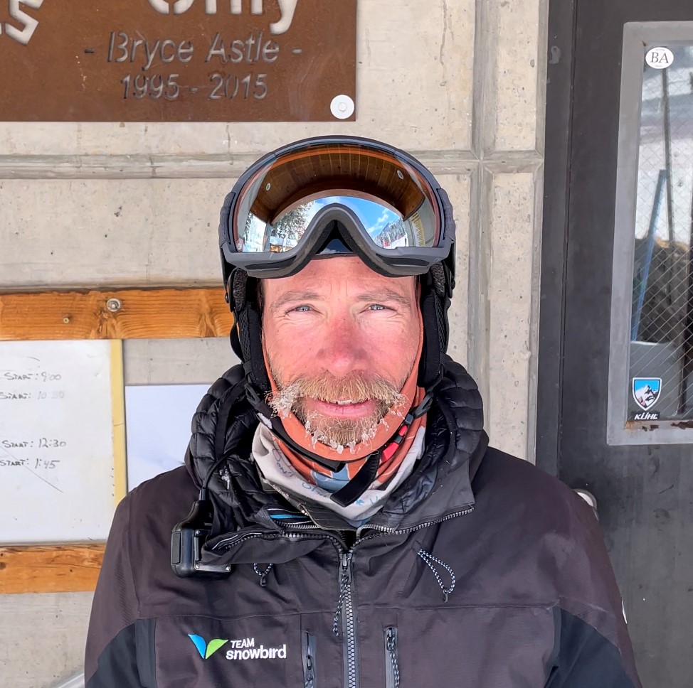 Smiling skier wearing goggles and winter jacket