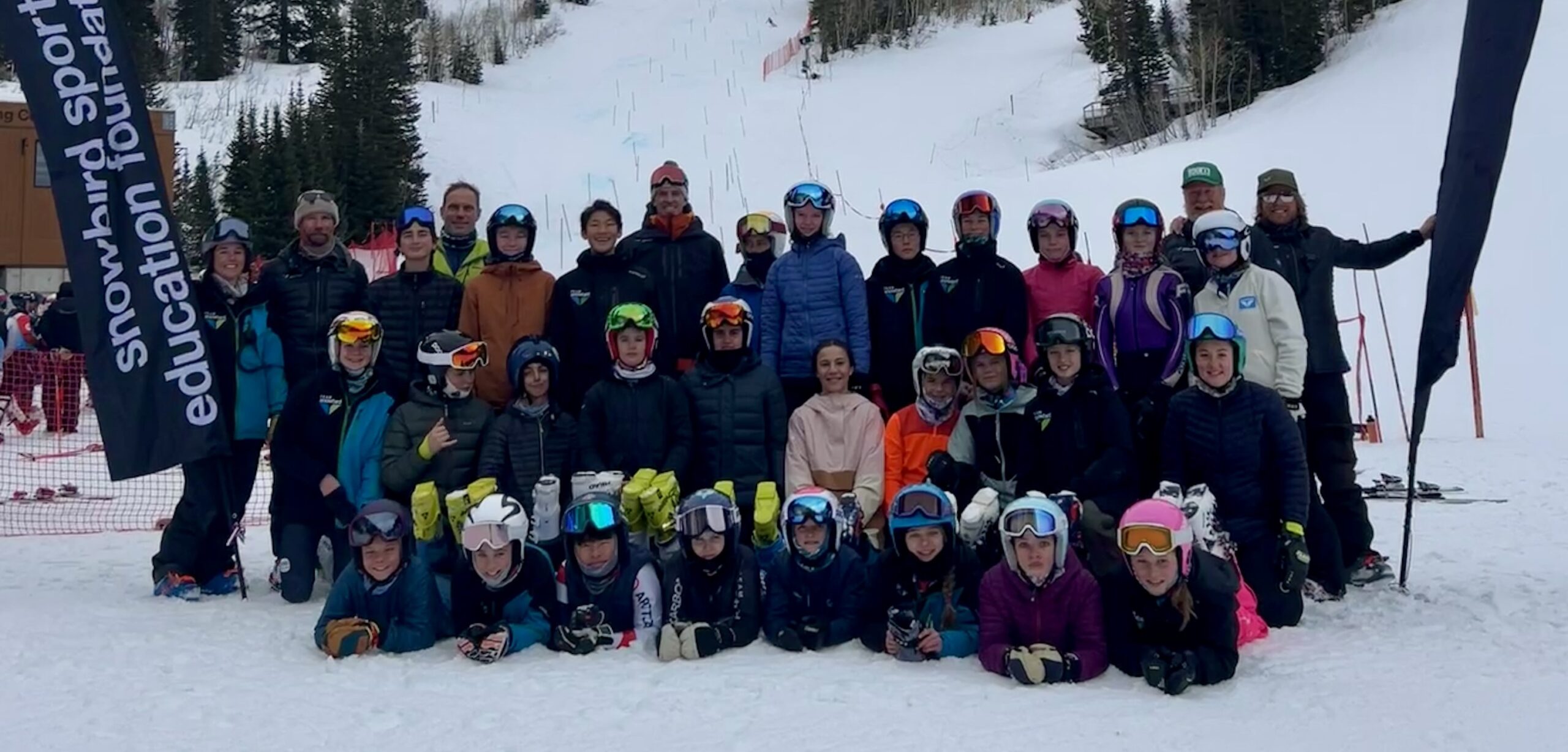 Large group of skiers posing on snowy slope
