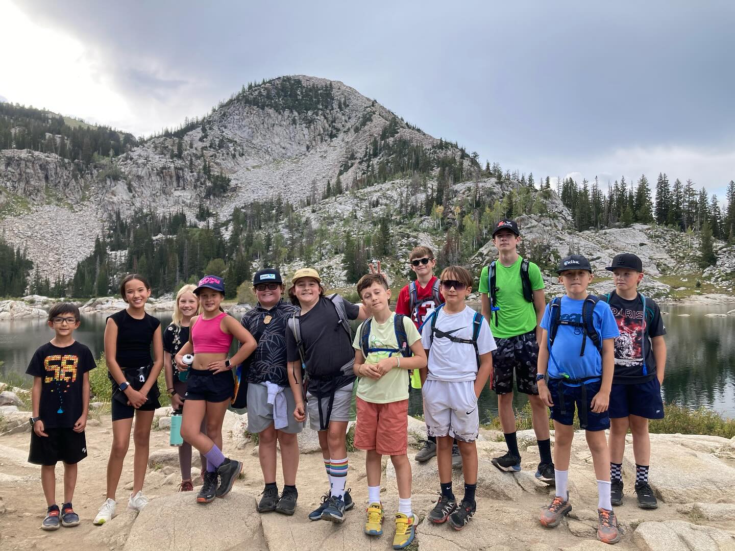 Group of kids hiking by mountain lake