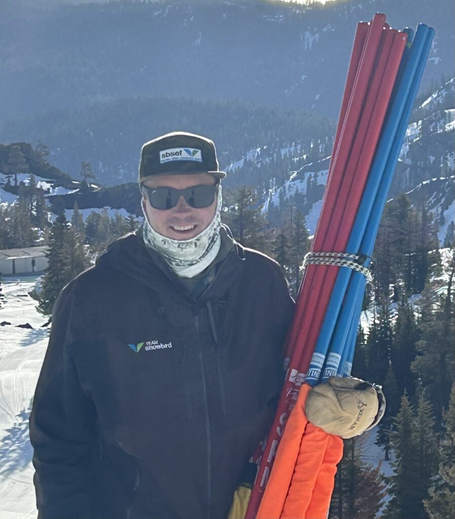 Person holding red and blue ski poles