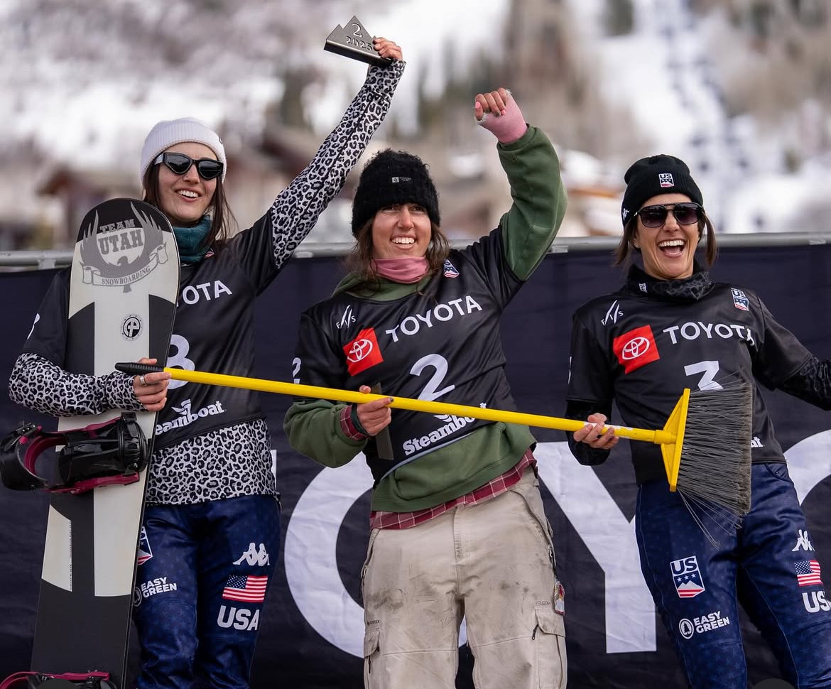 Three snowboarders celebrating on podium